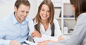 Smiling couple talking to a solicitor