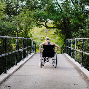 Person crossing a bridge in a wheelchair